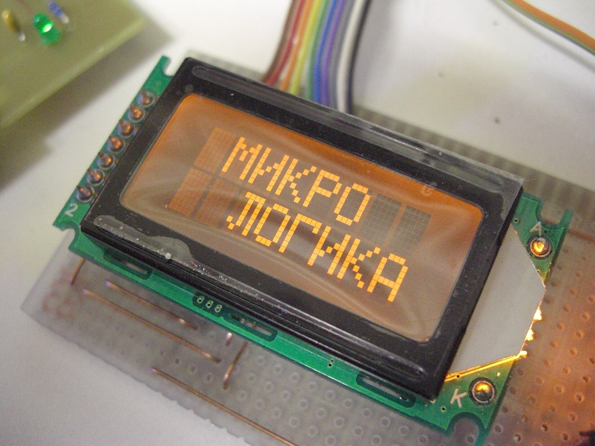 Photo of amber-backlit alphanumeric 8 characters by 2 lines HD44780 compatible LCD module. (Hitachi HD44780 LCD controller)